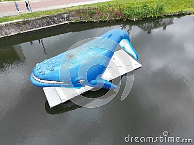 High-angle shot of a blue whale statue on a part of the Dender River in Dendermonde, Belgium Editorial Stock Photo
