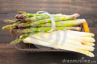 High angle shot of a bundle of green asparagus and white asparagus on a wooden table Stock Photo