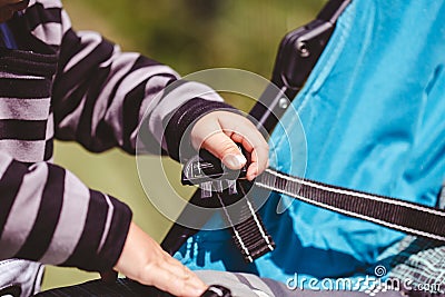 High angle shot of a child fixing his blue car seat captured on a sunny day Stock Photo