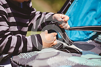 High angle shot of a child fixing his blue car seat captured on a sunny day Stock Photo