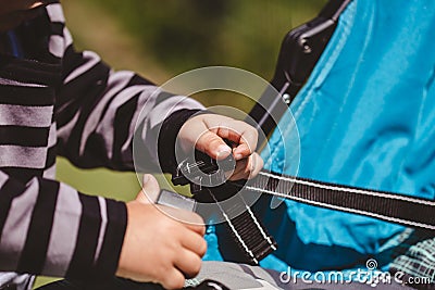 High angle shot of a child fixing his blue car seat captured on a sunny day Stock Photo