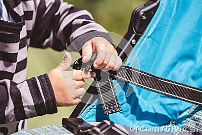 High angle shot of a child fixing his blue car seat captured on a sunny day Stock Photo