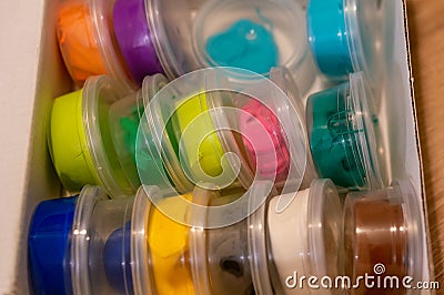 High angle shot of colorful play doughs in small packs in a box Stock Photo