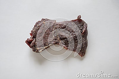High angle shot of a delicious piece of beef jerky on a white surface Stock Photo
