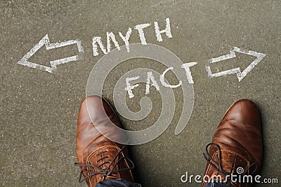 High angle shot of myth and fact marked with opposite directions on the ground Stock Photo