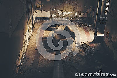 High angle shot of a vacant armchair in the center of a ruined room in an old building Stock Photo