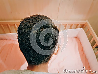 Back View of a Boy Preparing a Bed for New Family Member Stock Photo