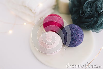 high angle view bath bombs loofah napkin illuminated fairy lights white surface. High quality photo Stock Photo