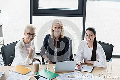 high angle view of beautiful businesswomen looking at camera at meeting Stock Photo