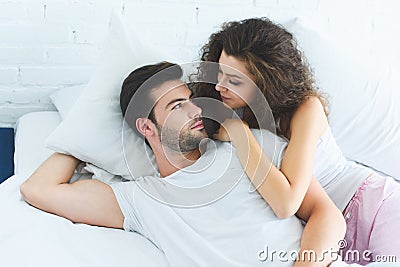 high angle view of beautiful young couple in love lying in bed and looking Stock Photo