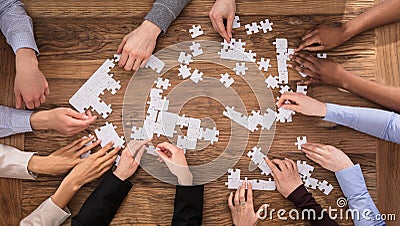 High Angle View Of Businesspeople Solving Jigsaw Puzzle Stock Photo