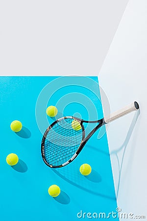high angle view circle of tennis balls around tennis racket on blue at white Stock Photo