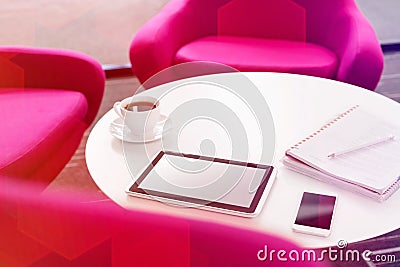 High angle view of digital tablet with coffee cup and smartphone on table by chairs at office Stock Photo