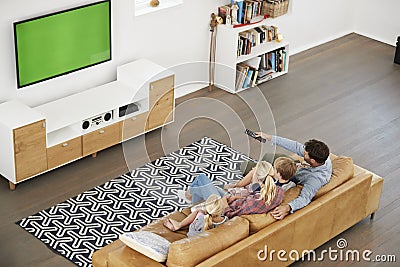 High Angle View Of Family Sitting On Sofa In Lounge Watching TV Stock Photo