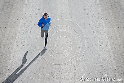 High angle view of female runner jogging on road city. Stock Photo