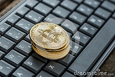 High angle view of four golden bitcoins on a keyboard Stock Photo