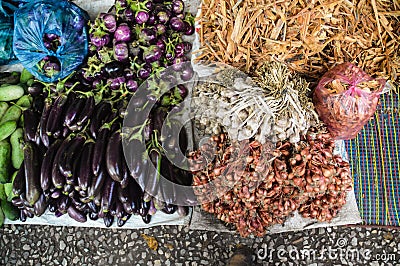 High angle view of fresh eggplants, shallots and garlic in the street market Stock Photo