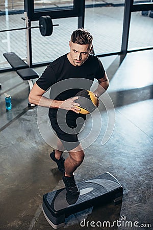 high angle view of handsome sportsman training on step platform with medicine ball Stock Photo