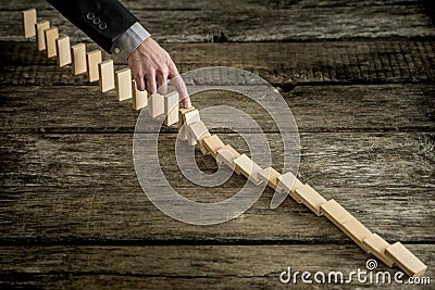 High angle view image of a businessman stopping domino effect Stock Photo