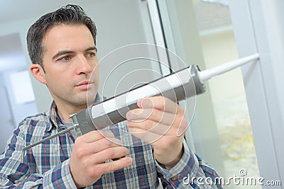 High angle view man applying silicone sealant Stock Photo