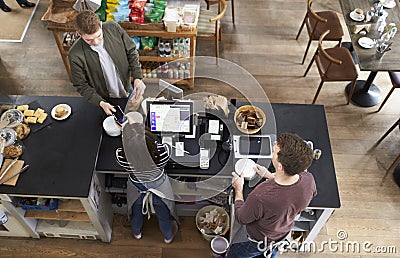 High angle view of man paying over counter at a coffee shop Stock Photo