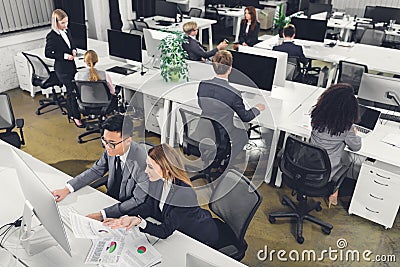 High angle view of multiethnic businesspeople working with papers and desktop computers Stock Photo