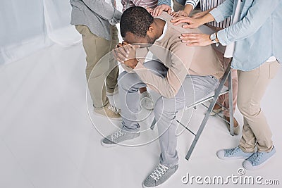 high angle view of people supporting depressed african american man Stock Photo