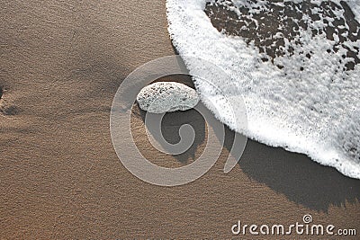 High angle view of stones on beach. Foam on a beach Stock Photo