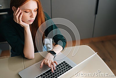 High-angle view of tired young woman office worker unmotivated and disinterested in dull work with laptop. Editorial Stock Photo