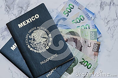 High angle view of two Mexican Passports and pesos on the table under the lights Stock Photo