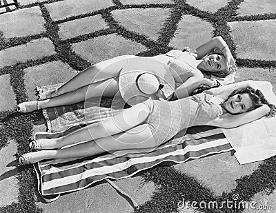 High angle view of two young women lying on a towel in the sun Stock Photo