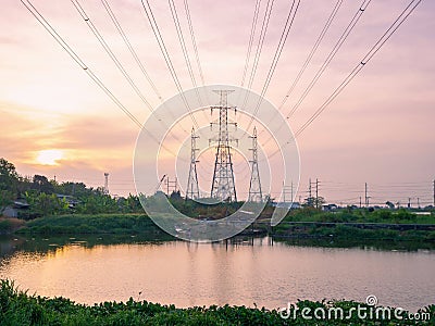 High angle view of high voltage transmission towers with power line over twilight sky background the electricity infrastructure Stock Photo