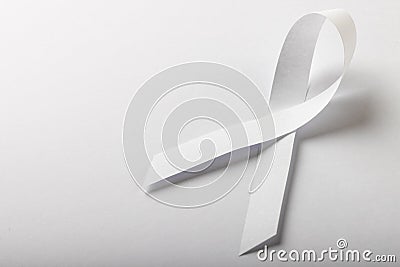 High angle view of white lung cancer awareness ribbon isolated against white background, copy space Stock Photo