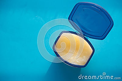 High angle view of white petroleum jelly on blue background Stock Photo