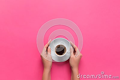 High angle of woman hands holding coffee cup on pink background Minimalistic style. Flat lay, top view isolated Stock Photo