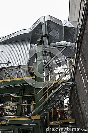 High, concrete industrial chimney and dust collector on a winter Stock Photo