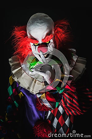Scary clown on a dark background Stock Photo