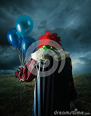 Scary clown on a field at night Stock Photo