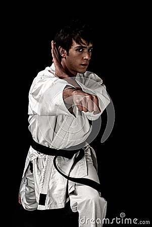High Contrast karate young male fighter on black Stock Photo