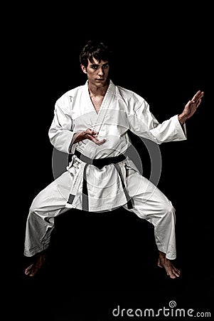 High Contrast karate young male fighter on black Stock Photo