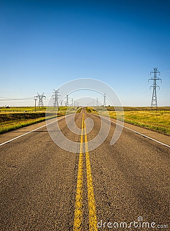 Electricity Pillars along an empty road in Alberta, Canada Stock Photo