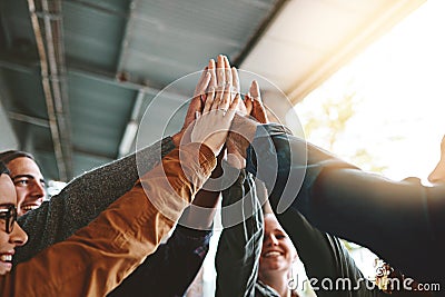 High five for acing that exam. a group of young students joining their hands together in solidarity on campus. Stock Photo