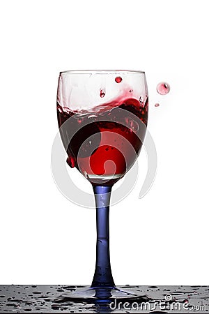 High glass of red wine in which fallen grapes Stock Photo