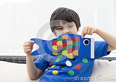 High key Portrait happy kid stay at home making coloufull Koinobori Carp streamers, Child boy doing Japanese fish kite in sunny Stock Photo