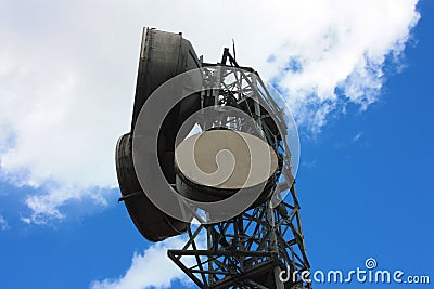 High large antennas transmitting signals with current satellite dishes and high intensity electrical cables Stock Photo