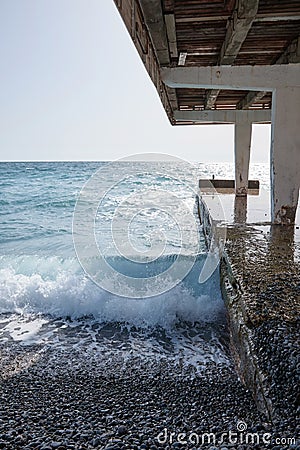Waves crashing on the shore, concrete breakwater, seascape, small storm at sea Stock Photo