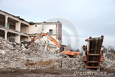 High Reach Excavator machines for demolition of tall building. Machine with hydraulic shears for demolish. Crushing Stock Photo