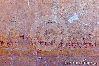 High Res ancient red limestone Egyptian vividly painted wall relief with detailed figures on a vessel Stock Photo