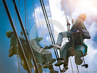 High rise window cleaner. Glass cleaner working. Most dangerous jobs in the building, cleaning and maintenance industries. Editorial Stock Photo