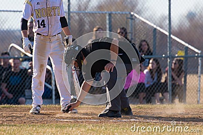 High school baseball umpire dusts off home plate Editorial Stock Photo